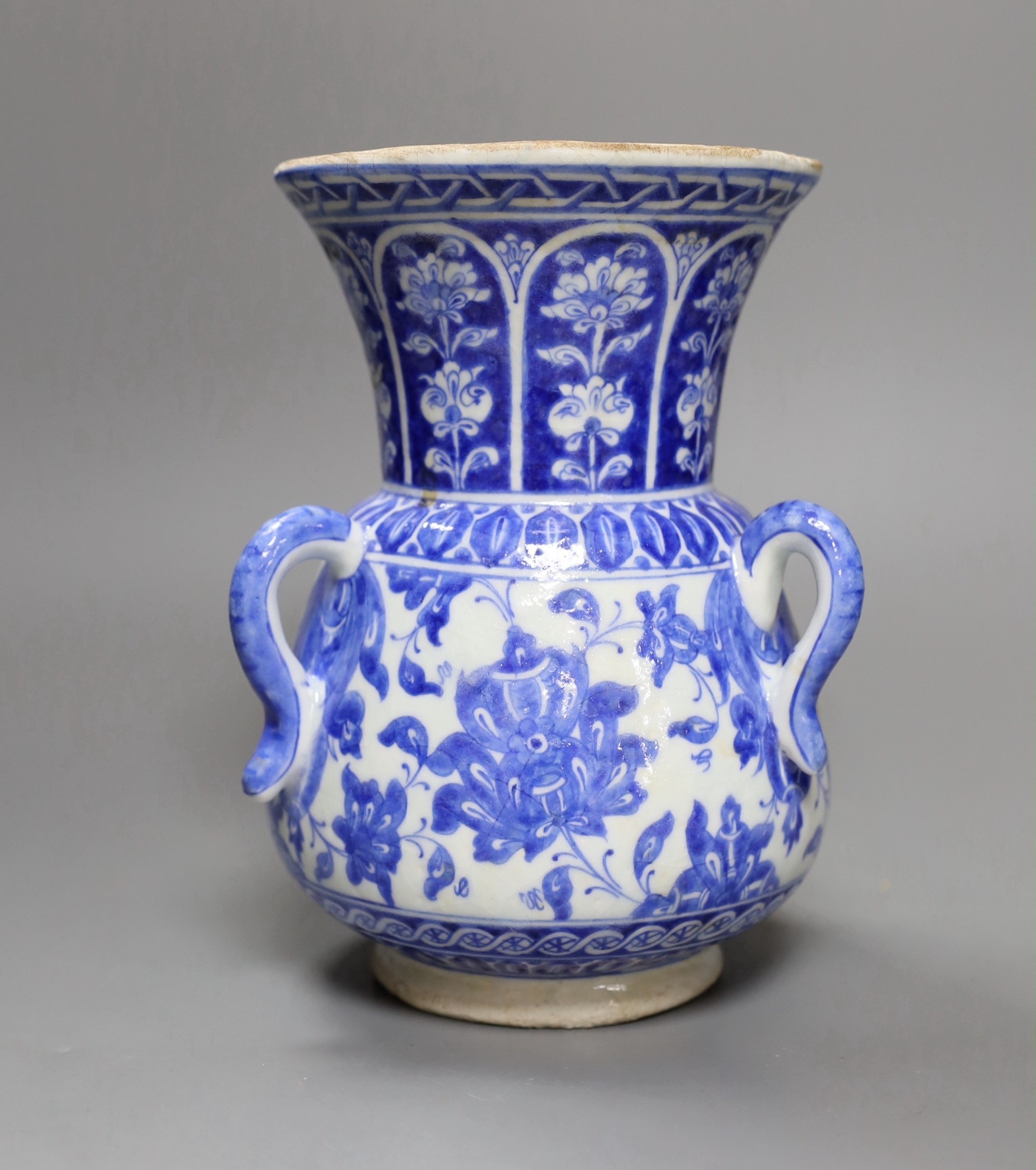 A three-handled blue and white Iznik pottery vase with floral motif, 22.5cm tall